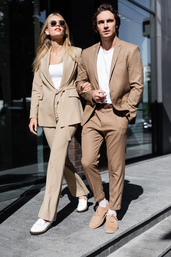 Full,Length,Of,Stylish,Couple,In,Beige,Suits,Walking,On